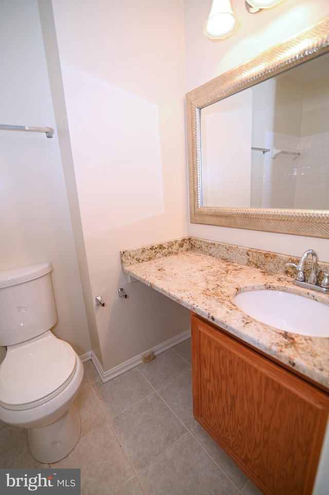 bathroom with tile patterned flooring, vanity, and toilet