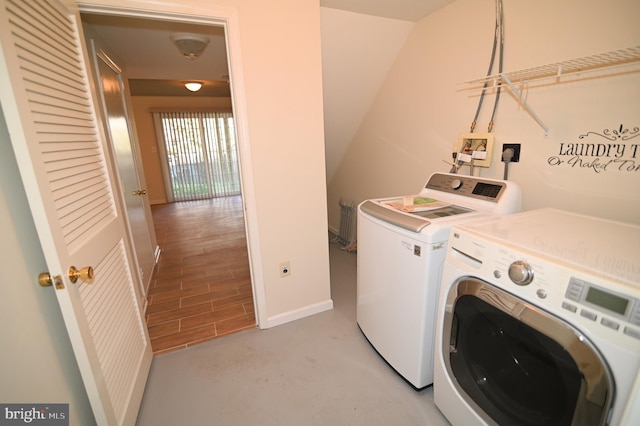 washroom with washing machine and dryer and light hardwood / wood-style flooring