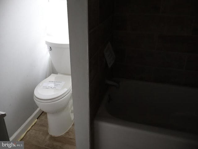 bathroom with toilet and a tub