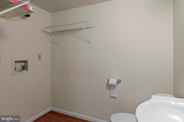 laundry room with laundry area, baseboards, wood finished floors, hookup for a washing machine, and a sink