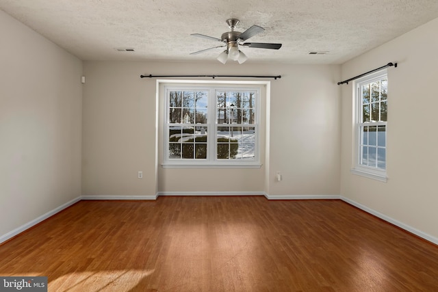 empty room with visible vents, baseboards, and wood finished floors