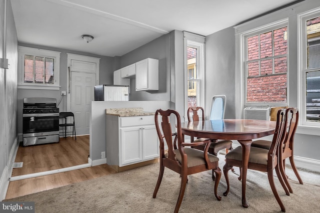 dining area featuring cooling unit and light hardwood / wood-style floors