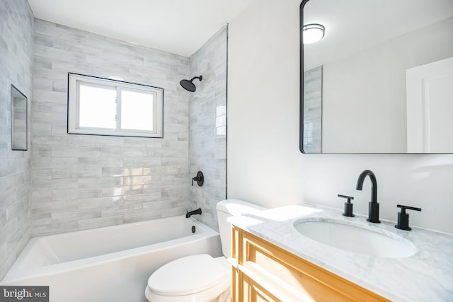 full bathroom featuring vanity, toilet, and tiled shower / bath