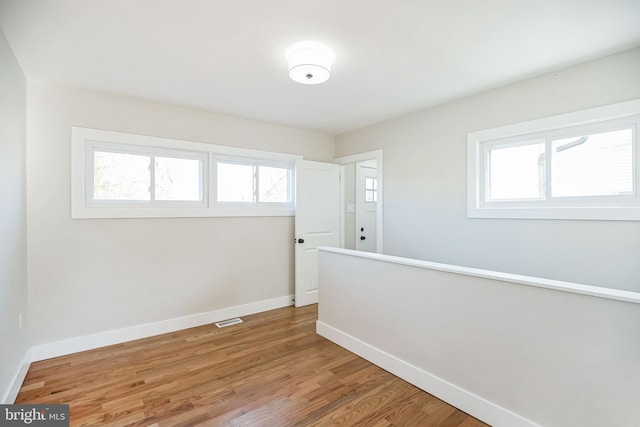 unfurnished room with hardwood / wood-style flooring