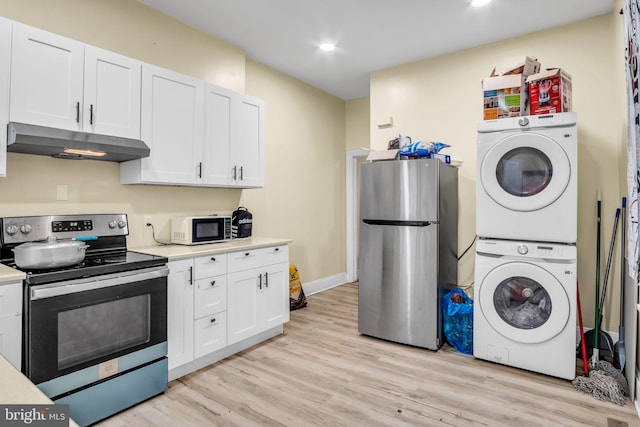 kitchen featuring white cabinets, appliances with stainless steel finishes, stacked washing maching and dryer, and light hardwood / wood-style flooring