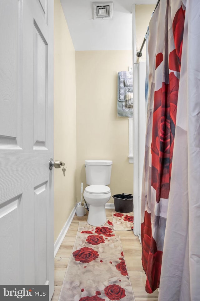 bathroom with hardwood / wood-style floors and toilet