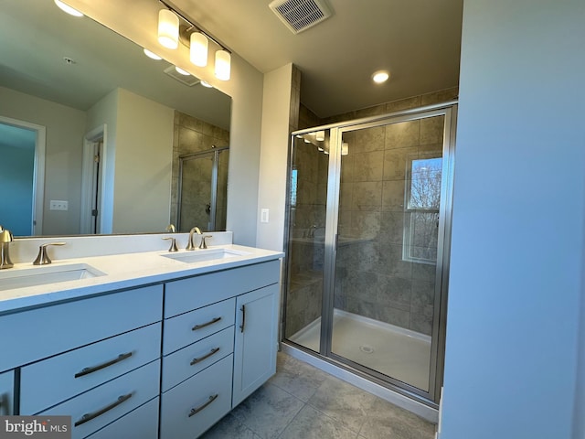 bathroom with tile patterned flooring, vanity, and a shower with door