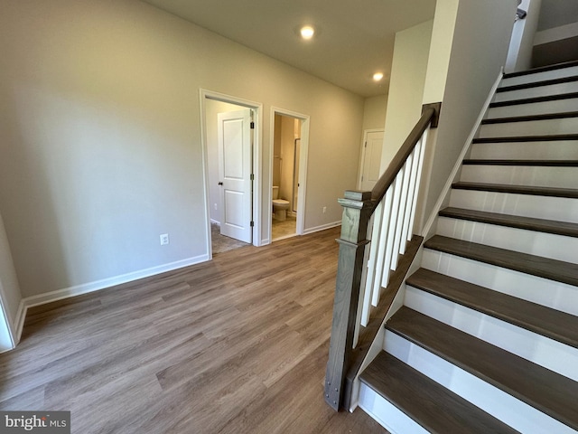 staircase featuring wood-type flooring