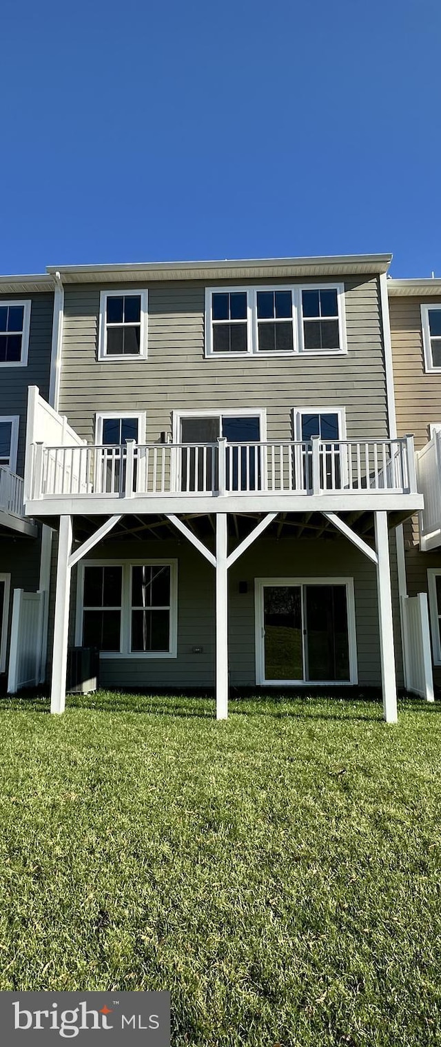 back of house featuring a deck and a lawn