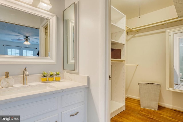 bathroom with wood-type flooring, vanity, and ceiling fan