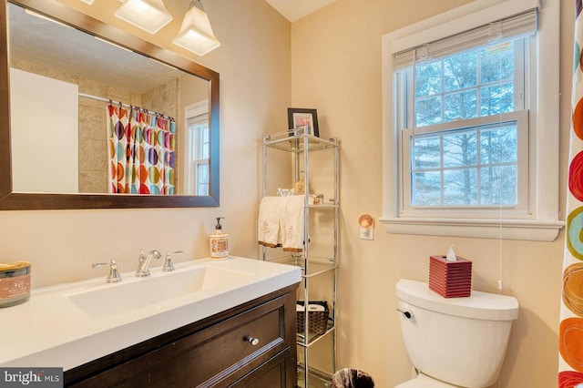 bathroom with plenty of natural light, vanity, and toilet