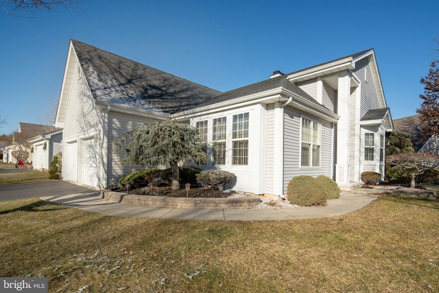 view of side of home with a lawn and a garage