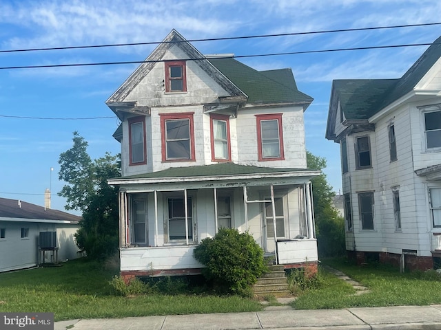 victorian home featuring covered porch and a front yard