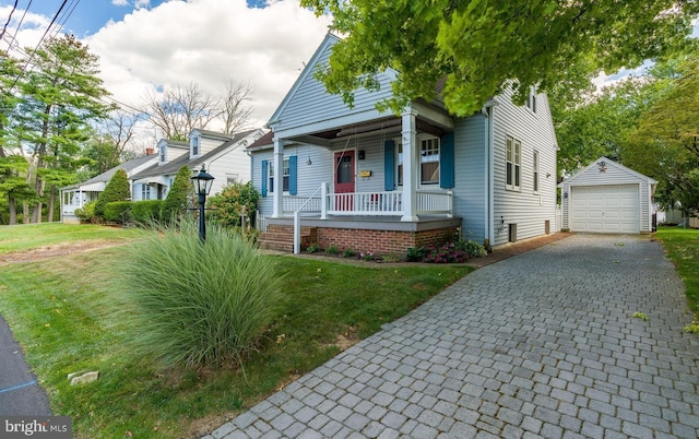 bungalow-style house with a porch, a front yard, an outdoor structure, and a garage