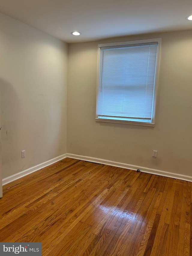 spare room with recessed lighting, wood finished floors, and baseboards