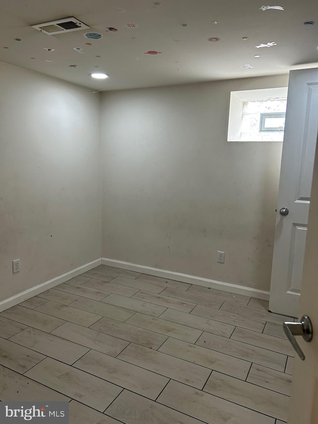 unfurnished room with visible vents, light wood-style flooring, and baseboards