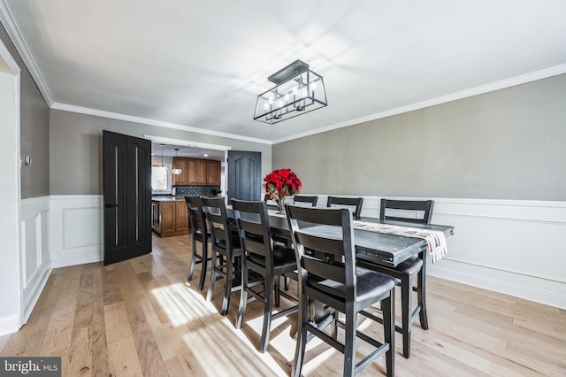 dining area featuring light hardwood / wood-style floors and ornamental molding