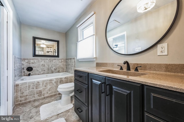 bathroom with vanity, tile patterned flooring, ceiling fan, toilet, and tiled tub