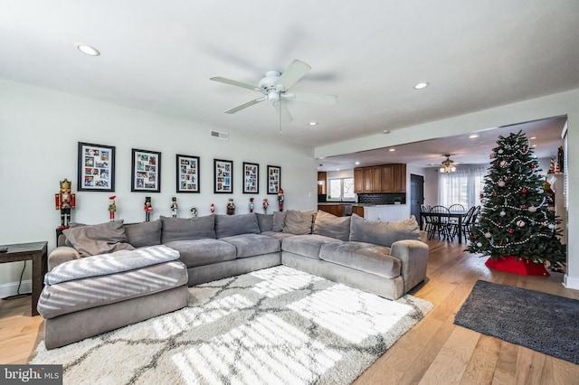 living room with ceiling fan and light hardwood / wood-style floors