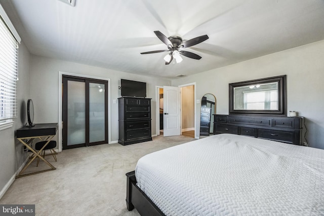 bedroom featuring multiple windows, light colored carpet, and ceiling fan