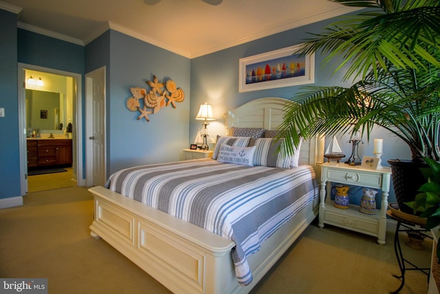 carpeted bedroom with ensuite bath, ceiling fan, and ornamental molding