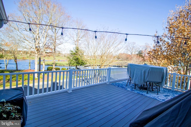 wooden terrace featuring grilling area and a water view