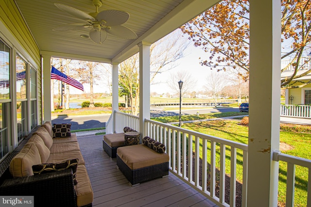 wooden deck featuring covered porch, a yard, and ceiling fan