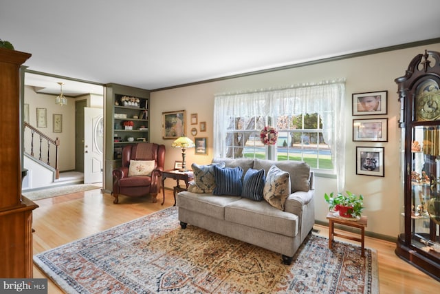 living room with crown molding and light wood-type flooring