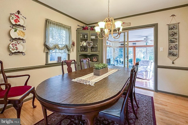 dining room featuring crown molding, a notable chandelier, plenty of natural light, and light wood-type flooring