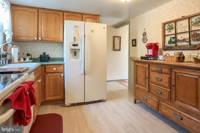 kitchen with sink, light hardwood / wood-style floors, and white fridge with ice dispenser