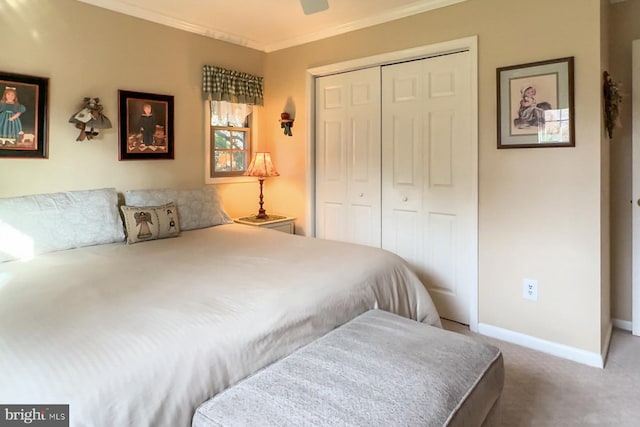 bedroom with crown molding, ceiling fan, carpet flooring, and a closet