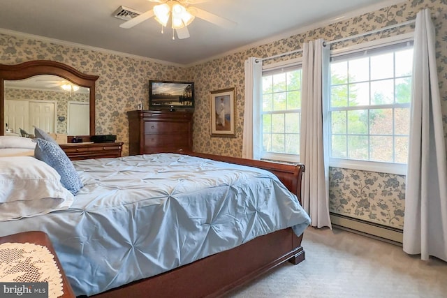 carpeted bedroom with crown molding, ceiling fan, and a baseboard heating unit