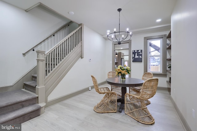 dining room with light wood-type flooring and a notable chandelier