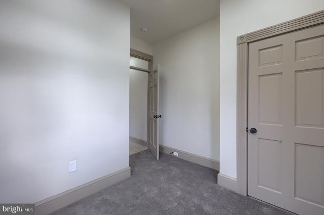 unfurnished bedroom with dark carpet