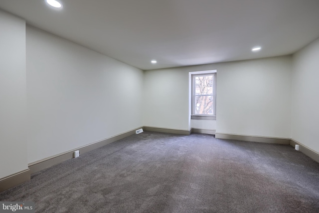 unfurnished room with dark carpet