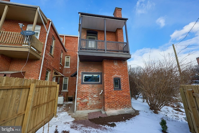 snow covered property featuring a balcony