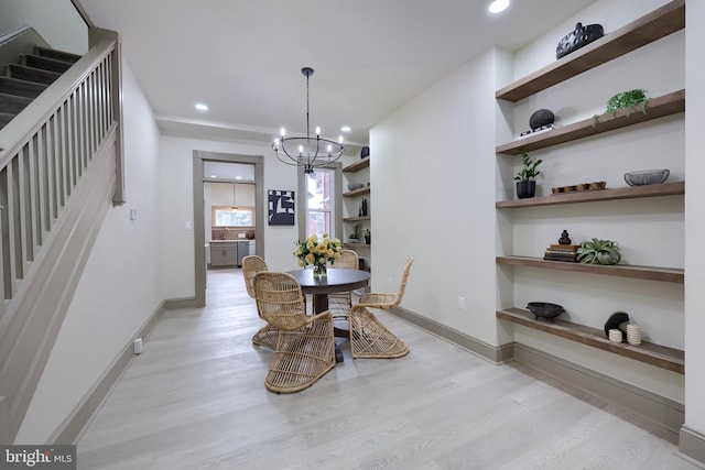 dining space with a chandelier and light hardwood / wood-style floors