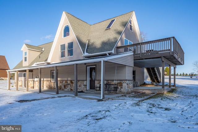 snow covered house featuring a deck