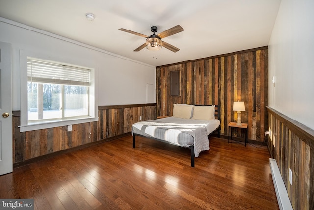 bedroom with ceiling fan, ornamental molding, baseboard heating, and dark wood-type flooring