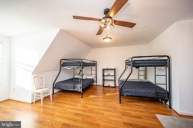 bedroom with ceiling fan, light hardwood / wood-style floors, and lofted ceiling