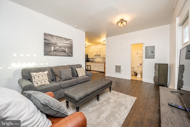 living room with dark wood-type flooring and electric panel