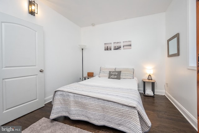 bedroom with dark hardwood / wood-style floors