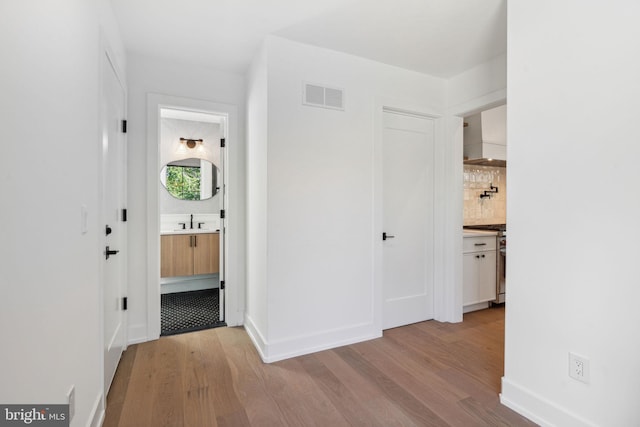 hall featuring sink and light wood-type flooring