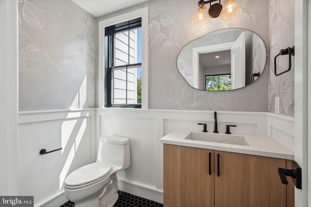 bathroom with a wealth of natural light, vanity, and toilet