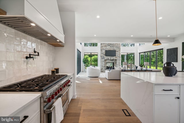 kitchen with white cabinetry, pendant lighting, double oven range, and custom exhaust hood