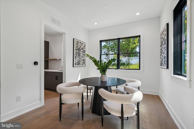 dining space with a wealth of natural light and dark hardwood / wood-style floors