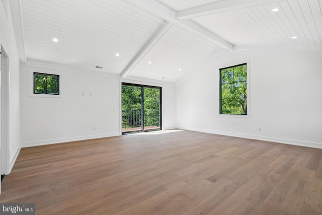 unfurnished room with vaulted ceiling with beams and light hardwood / wood-style floors