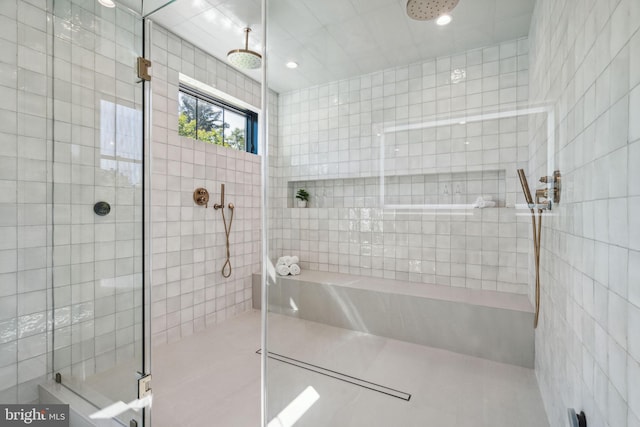 bathroom with tile patterned floors, tile walls, and walk in shower