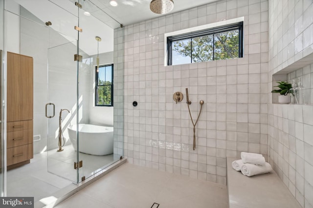 bathroom featuring tile patterned flooring, separate shower and tub, and tile walls