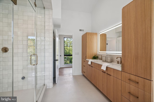 bathroom featuring a towering ceiling, vanity, and an enclosed shower